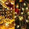 A collage of images showing snowflake-shaped LED string lights, some draped on Christmas stockings, others on a decorated Christmas tree, and close-ups of the lights. Produktbild-Vorschau