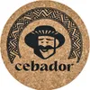 A round cork coaster with a black graphic design of a man wearing a hat and the word 'cebador' below. Voir les images du produit