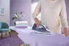 A person is ironing clothes on an ironing board. Voir les images du produit