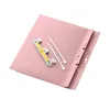 A pink folder with a binding mechanism and two white plastic strips. Anteprima dell’immagine prodotto