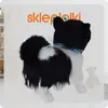 A plush dog toy with a collar, placed in a room with shelves and a teddy bear in the background. Anteprima dell’immagine prodotto