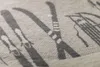 A close-up view of a textured fabric with a printed pattern of skis and sleds. Produktbild-Vorschau