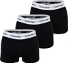 Three black boxer shorts are arranged diagonally on a white background. Podgląd zdjęcia produktu