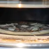 A pizza is being cooked in an oven. Náhled obrázku produktu