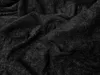A close-up, textured view of a black fabric, likely a bedsheet. Náhled obrázku produktu