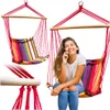 A woman is sitting in a colorful hammock chair and talking on her phone. Náhled obrázku produktu