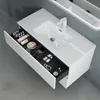 A modern bathroom vanity with an open drawer displaying various cosmetic items. Produktbild-Vorschau