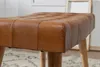 Close-up of a brown leather ottoman with wooden legs. Náhled obrázku produktu