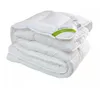 A folded white duvet with a green and white label on it, set against a white background. Podgląd zdjęcia produktu