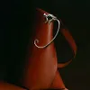 A close-up studio shot of a brown leather handbag with a silver metallic handle. Anteprima dell’immagine prodotto