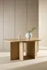 A light wood oval dining table with a vase and a candle on it, set against a neutral wall. Voir les images du produit