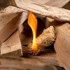Close-up of wood wool fire starters igniting within a pile of firewood. Podgląd zdjęcia produktu