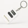 A white digital keychain clock with a silver keyring and chain, displayed on a white background. Produktbild-Vorschau