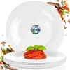 A stack of white dinner plates with a portion of spaghetti on the top plate, surrounded by scattered ingredients. Náhľad obrázku produktu