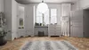 A well-lit room with a white wardrobe, a chest of drawers, a floor lamp, and a rug on a wooden floor. Produktbild-Vorschau