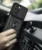 A hand holding a black phone case with a ring stand in a car. Produktbild-Vorschau