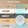 A robotic vacuum cleaner is shown on a floor with different types of flooring and stains, illustrating its versatility. Produktbild-Vorschau