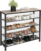 A multi-tiered shoe rack filled with various types of shoes, topped with a plant and books. Náhled obrázku produktu