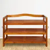 A wooden shoe rack with three shelves against a white wall. Anteprima dell’immagine prodotto