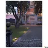 A stately home with a driveway illuminated by several outdoor lights. Produktbild-Vorschau