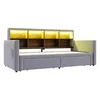 A light gray upholstered bed frame with a built-in headboard featuring wooden shelves and LED lighting. Náhled obrázku produktu