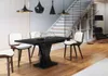 A modern dining room with a black dining table and chairs, a staircase, and a bookshelf. Anteprima dell’immagine prodotto