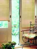 A view through an open door to a garden, with a chair and plants in the foreground. Náhled obrázku produktu