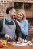 A couple is preparing food in a kitchen. Produktbild-Vorschau