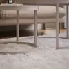 A close-up view of a white shag rug with two nested coffee tables in a living room setting. Náhľad obrázku produktu
