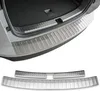 A close-up view of a car's rear bumper and trunk area, showcasing a stainless steel protector. Produktbild-Vorschau