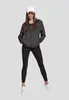 A woman wearing a black windbreaker and black leggings stands against a plain gray background. Produktbild-Vorschau