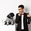A man in a suit and a dog in a sweater are posing for a photo with a bottle of champagne. Produktbild-Vorschau