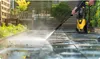 A person is using a pressure washer to clean a tiled patio. Náhľad obrázku produktu