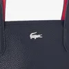 A close-up view of a dark blue handbag with a silver crocodile logo and a red interior lining. Anteprima dell’immagine prodotto