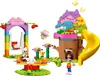A colorful LEGO playset depicting a garden party scene with a treehouse, swing, slide, and carousel. Produktbild-Vorschau