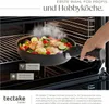 A hand is holding a frying pan filled with food inside an oven. Náhled obrázku produktu