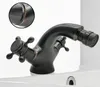 A close-up shot of a black bidet faucet with bronze accents, placed on a white sink. Anteprima dell’immagine prodotto