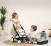 Two children playing with a doll and a toy stroller. Produktbild-Vorschau