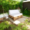 A white cushion set on a pallet sofa in a garden setting. Podgląd zdjęcia produktu