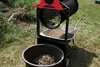 A trommel sieve is set up outdoors, with a wheelbarrow collecting sifted soil and a bucket below for larger debris. Náhľad obrázku produktu