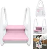 A pink and white two-step stool for children, shown in a lifestyle setting by a bathroom sink, and also as isolated product shots. Voir les images du produit
