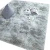 A fluffy gray rug with a pillow and an open book on it. Náhled obrázku produktu