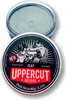 A tin of Uppercut Deluxe Clay hair product is shown with its lid open, revealing the product inside. The lid features a graphic of two boxers. Anteprima dell’immagine prodotto