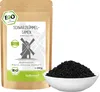 A bag of black cumin seeds next to a bowl of the seeds, with the product packaging prominently displayed. Produktbild-Vorschau