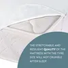 A close-up view of a mattress protector being pulled back to reveal the mattress underneath. Produktbild-Vorschau