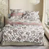 A neatly made bed with patterned bedding in a room. Produktbild-Vorschau