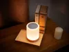A bedside table with a lamp, books, and a candle. Voir les images du produit