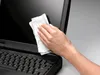 A hand is cleaning a laptop screen with a wipe. Náhled obrázku produktu