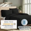 A black bedding set is displayed on a bed, with certifications and quality marks overlaid. Produktbild-Vorschau