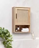 A wooden bathroom cabinet with a rattan front is mounted on a tiled wall. Podgląd zdjęcia produktu